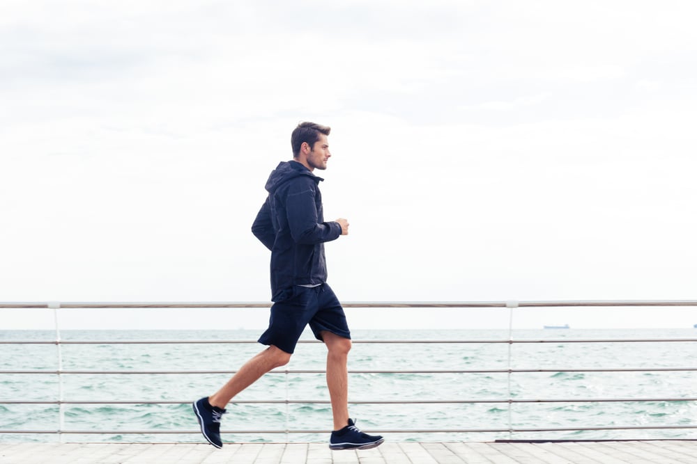 Side view portrait of a sports man running outdoors